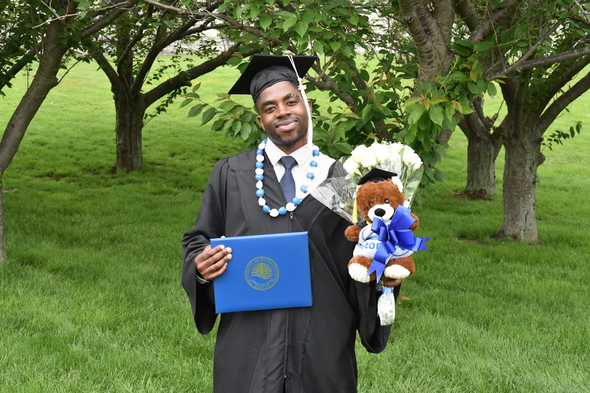 Ibrahim Kaba at his UMass Boston graduation, holding his diploma